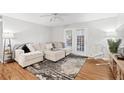 Cozy living room with a plush sofa, neutral tones, and a door leading to the outside at 106 Brighton Pt, Atlanta, GA 30328