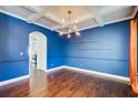 Formal dining room with coffered ceiling, hardwood floors and modern lighting fixture at 3483 Summerlin Pkwy, Lithia Springs, GA 30122
