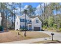 Two story home with gray siding, dark shutters, and a well-manicured lawn and long driveway at 2099 Easterwood Ter, Decatur, GA 30032