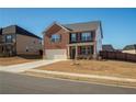 Two-story brick home with a two-car garage, complemented by a neatly maintained lawn and inviting curb appeal at 3469 English Elm Way, Loganville, GA 30052