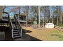 Backyard featuring a wooden deck, a storage shed, and a chicken coop surrounded by mature trees at 705 Mill Creek Rdg, Woodstock, GA 30188