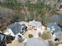 Aerial view of waterfront homes, featuring well-manicured lawns and mature trees in a quiet neighborhood at 335 Lake Bluff Ct, Suwanee, GA 30024