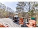 Outdoor deck area, perfect for entertaining with comfortable seating, barbecue, and lake views at 335 Lake Bluff Ct, Suwanee, GA 30024