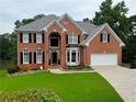 Stunning two-story brick home with a well-manicured lawn and attached two car garage at 335 Lake Bluff Ct, Suwanee, GA 30024