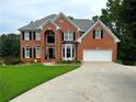 Handsome two-story brick home with lush lawn, bay window, and two-car garage at 335 Lake Bluff Ct, Suwanee, GA 30024