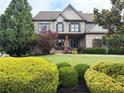 Beautifully landscaped front lawn with manicured shrubs and mature trees enhances this home's curb appeal at 4020 Toulon Ln, Cumming, GA 30040