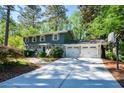 Spacious driveway leading to a two-car garage with a basketball hoop in a lush, green neighborhood at 4400 Huntington Cir, Dunwoody, GA 30338