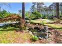 Beautifully landscaped front yard with a serene pond and mature trees, offering a peaceful ambiance at 4400 Huntington Cir, Dunwoody, GA 30338