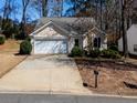Single-story home with an attached garage, driveway, and minimal landscaping at 509 Carrington Ct, Canton, GA 30115