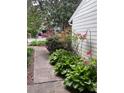Landscaped walkway with beautiful hostas and flowering bushes, adding a touch of nature to the home's entrance at 165 Woodhaven Way, Alpharetta, GA 30009