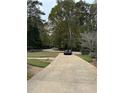 Long driveway leading to a home surrounded by lush greenery and mature trees at 3200 Farmington, Vinings, GA 30339