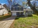 Charming two-story home features an attached garage, a well-manicured lawn and a yellow front door at 4665 Garden Hills Dr, Stone Mountain, GA 30083