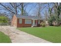 This brick home features a driveway and a well-manicured lawn at 1883 Clarke Ln, Decatur, GA 30035