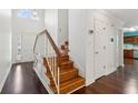 Welcoming foyer with hardwood floors, staircase, and view to kitchen area at 3923 Ashford Lake Ne Ct, Brookhaven, GA 30319
