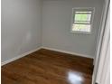 Cozy bedroom with neutral walls and hardwood flooring; brightened by natural light from the window at 877 Verona Dr, Clarkston, GA 30021