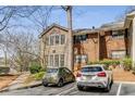 Exterior shot of condo complex featuring both tan siding, brick, and parked cars at 102 Barrington Hills Dr, Atlanta, GA 30350