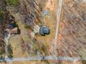 Aerial view of a quaint home on a private lot, surrounded by mature trees, walking trails, and a fire pit at 118 Raven Rd, Villa Rica, GA 30180