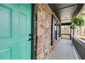 Close-up of the porch featuring stone accents, a hanging fern, and a turquoise front door at 118 Raven Rd, Villa Rica, GA 30180