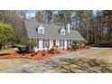 View of the house showing manicured yard with mature trees, a circular driveway, and a well-maintained lawn at 4053 Thompson Mill Rd, Buford, GA 30519