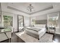Bright main bedroom features tray ceiling, large windows, and a plush rug at 1007 Belle Ave, Roswell, GA 30076
