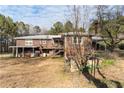 A two-story brick home with a back porch and stone decor accents surrounded by greenery at 2443 Highway 92 S, Fayetteville, GA 30215