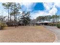 A single-story home with a long driveway and expansive front yard, set against a backdrop of mature trees at 2443 Highway 92 S, Fayetteville, GA 30215