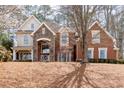 Beautiful brick and stone home with manicured lawn and mature trees in a quiet neighborhood at 706 Registry Run, Kennesaw, GA 30152