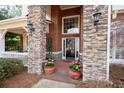 Close-up of a beautiful stone and brick entrance with potted plants and a glass-paneled door at 706 Registry Run, Kennesaw, GA 30152