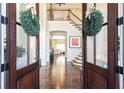 Inviting foyer with hardwood floors, a staircase leading to an open landing, and decorative wreaths on glass doors at 825 Glengate Pl, Atlanta, GA 30328