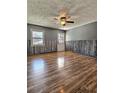 Bright living room featuring hardwood floors, textured ceilings, and stylish wood paneling at 1320 Milstead Ne Ave, Conyers, GA 30012