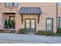 Stylish brick townhome entrances with manicured landscaping and metal awnings at 6601 Cadence Blvd, Atlanta, GA 30328