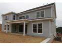 Rear exterior view showing the covered porch and large windows, highlighting outdoor living and natural light, perfect for relaxation at 444 Lower Shoreline Ct Sw, Marietta, GA 30064
