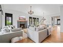 Bright living room with fireplace, hardwood floors, and designer furnishings at 6845 Wesley Hughes Rd, Cumming, GA 30040