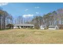 Spacious property featuring a large yard, main house and detached garages against a backdrop of lush trees at 9991 Holly Hill Way, Jonesboro, GA 30238