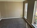 Cozy bedroom featuring neutral paint, plush carpet, and two large windows for natural light at 5942 King Way Walk, Lithonia, GA 30058