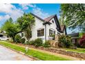 Angle-view of a charming two-story home with white painted brick, dark trim, and landscaped yard at 1448 N Highland Ne Ave, Atlanta, GA 30306