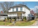 Charming two-story home with a covered porch, manicured lawn, and black metal fencing at 969 Parsons Sw St, Atlanta, GA 30314