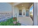 Charming front porch with stone accents, a blue front door and lush landscaping for added curb appeal at 5638 Maple Bluff Way, Hoschton, GA 30548