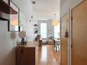 Hallway featuring hardwood floors, wall art, and leading to a living room area with natural light at 2630 Talley St # 426, Decatur, GA 30030