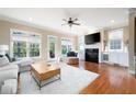 Cozy living room with ample windows, a fireplace, and hardwood floors, creating a perfect relaxation space at 1020 Constitution Way, Cumming, GA 30040