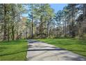 Long private driveway leading to a secluded home, surrounded by mature trees and green lawns at 2051 E Piedmont Rd, Marietta, GA 30062