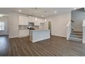 Sunlit living room boasts wood-look floors, an eat-in kitchen, and easy access to the staircase, enhancing the home's appeal at 4544 Eastbrook Pl, Snellville, GA 30039