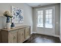 Inviting entryway with dark hardwood floors, stylish console table, and double doors with bright natural light at 6596 Aria Village Dr # 642, Atlanta, GA 30328