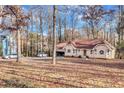 Scenic view of the front of this tan home with a two-car garage and a leaf-covered yard at 9224 Snipe Ln, Jonesboro, GA 30236