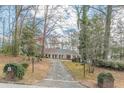View of a home from a long cracked driveway surrounded by mature trees at 3390 Somerset Sw Trl, Atlanta, GA 30331