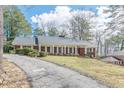 Brick home with white columns and shutters lining the porch overlooking a well-manicured lawn at 3390 Somerset Sw Trl, Atlanta, GA 30331