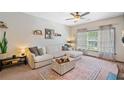 Bright living room with a large sofa, ceiling fan, and decorative rug at 407 The Crossings Ln, Woodstock, GA 30189