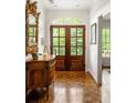 Elegant foyer featuring hardwood floors, a decorative mirror, and a glass paneled double front door at 4183 Paran Pines Nw Dr, Atlanta, GA 30327