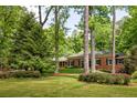 Beautiful single-story brick home with manicured lawn and trees adding privacy and charm at 4183 Paran Pines Nw Dr, Atlanta, GA 30327