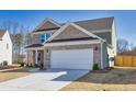 Side view of a well-maintained two-story home with a spacious driveway leading to an attached two-car garage at 1436 Maston Rd, Auburn, GA 30011